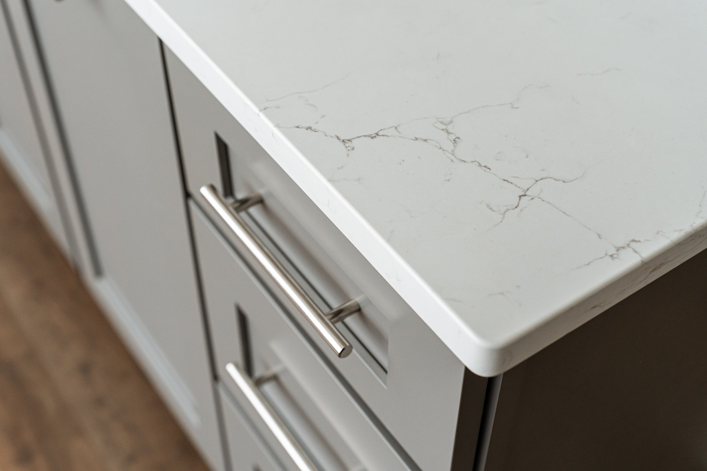 Basement wet bar area with gray cabinetry and quartz countertops