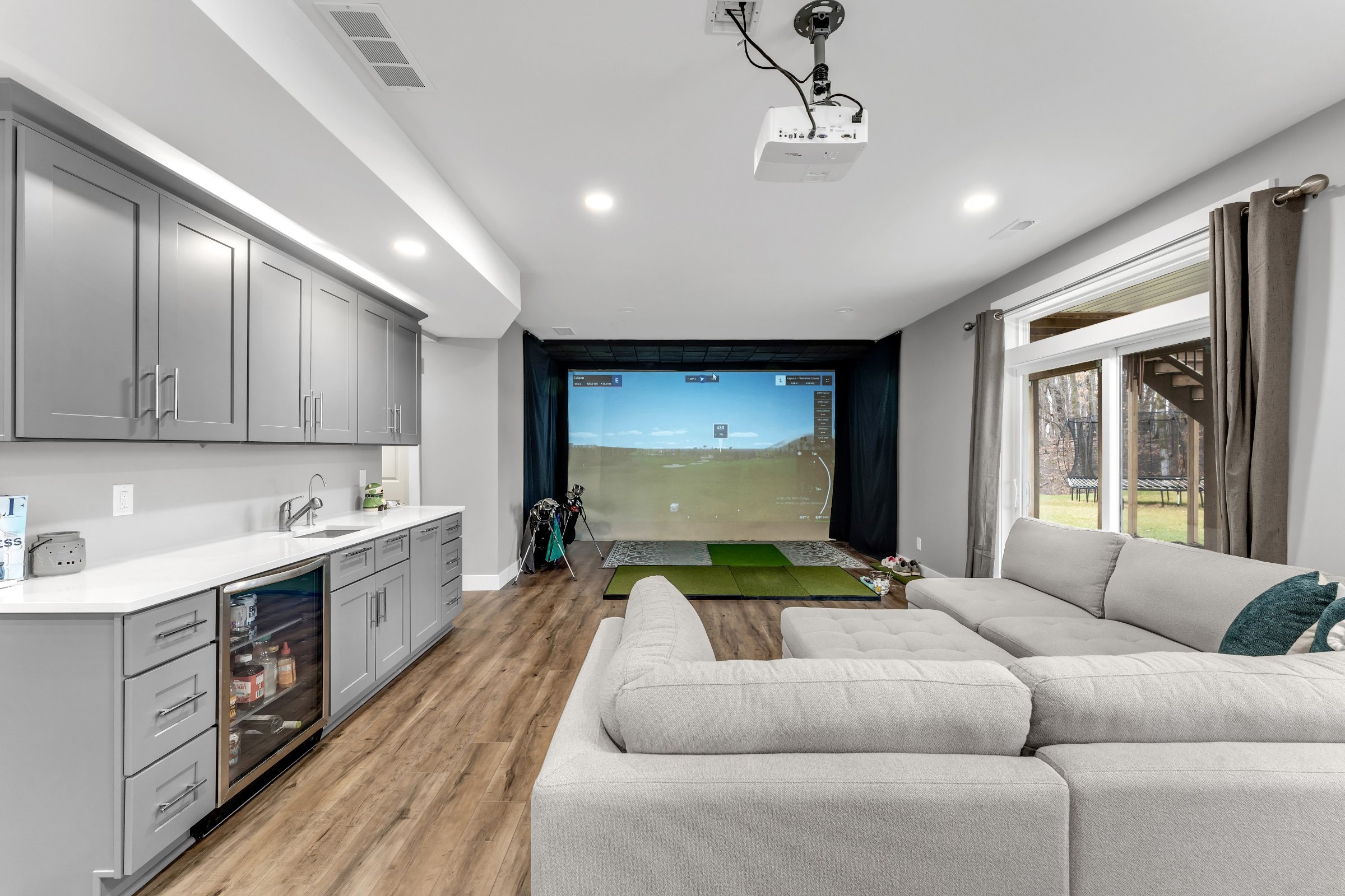 Golf simulator room with dedicated lighting and open floor plan