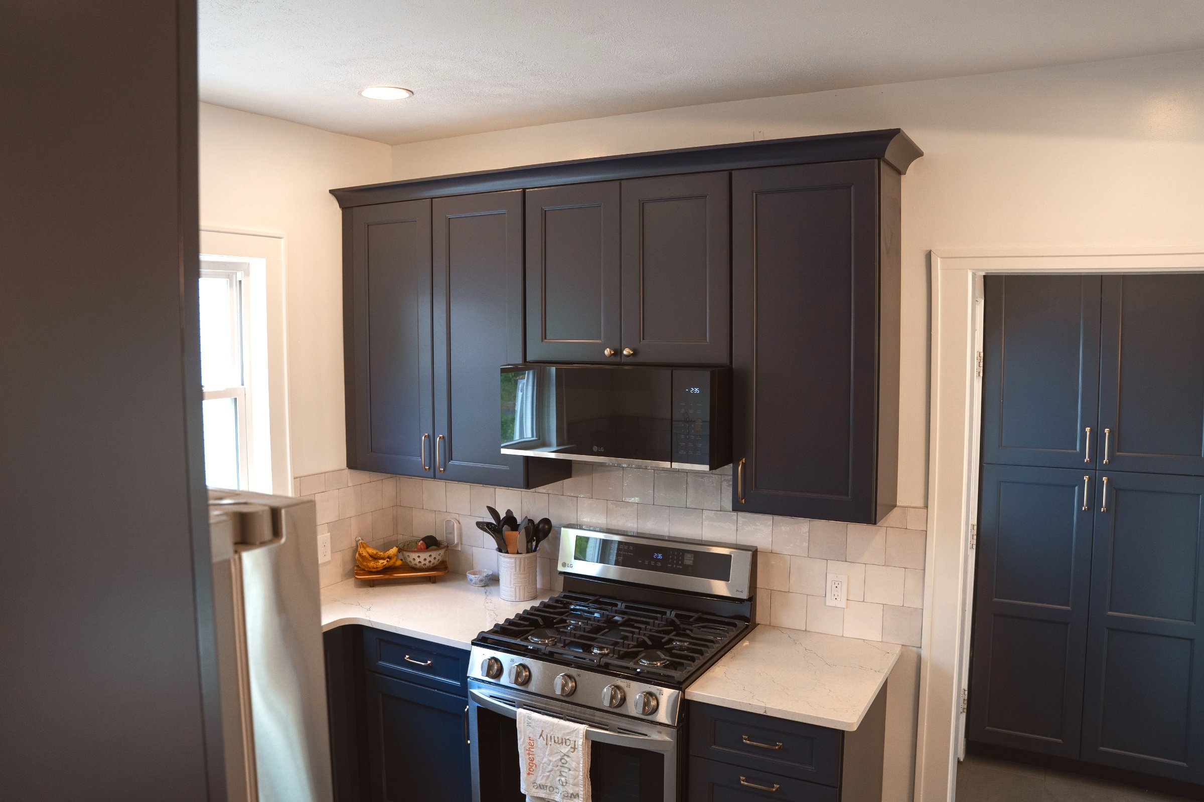 Navy & Gold kitchen remodel — navy blue shaker cabinets, white quartz countertops, gold hardware and farmhouse sink
