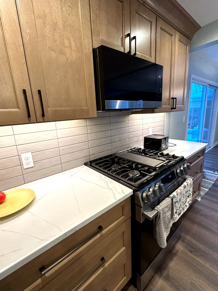 Modern kitchen — under-cabinet lighting, quartz countertops, tile backsplash