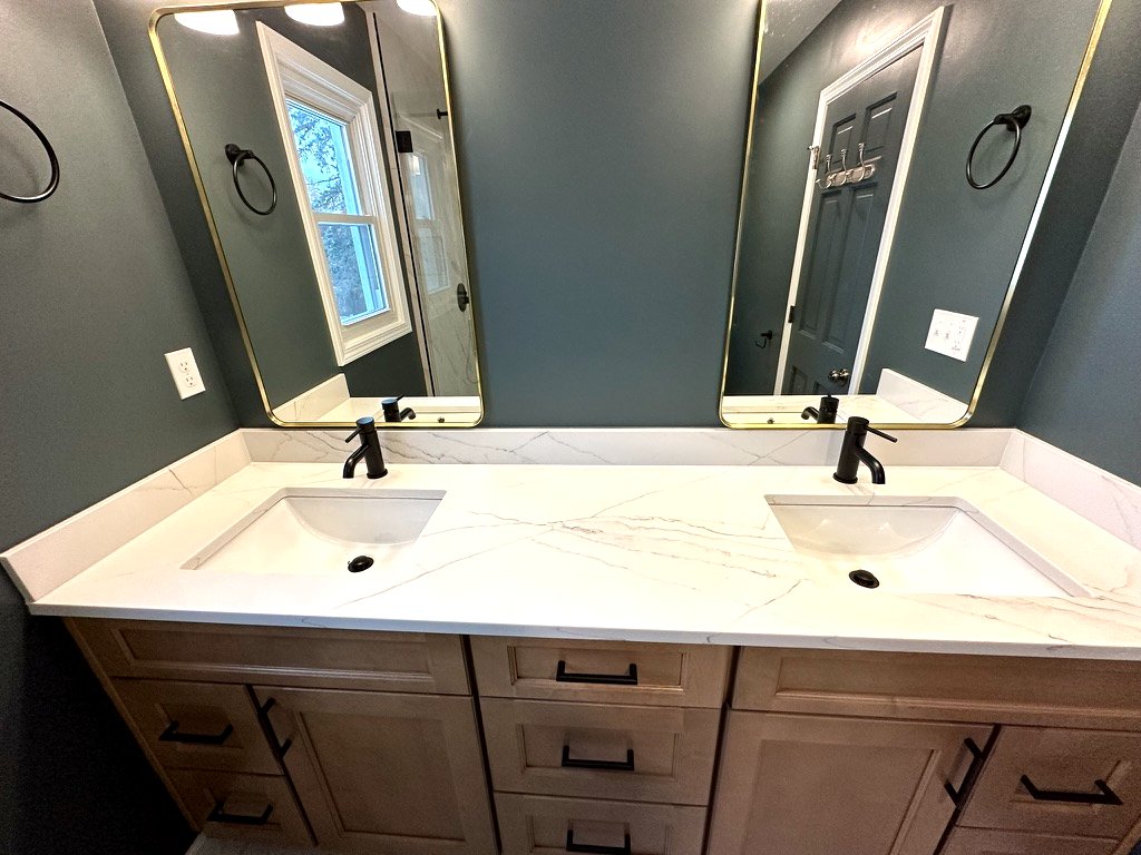 Modern Sophistication bathroom — dual vanity with warm wood cabinet and modern lighting