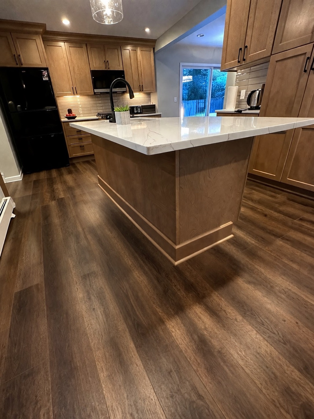Modern kitchen remodel — white quartz island countertop with wood flooring