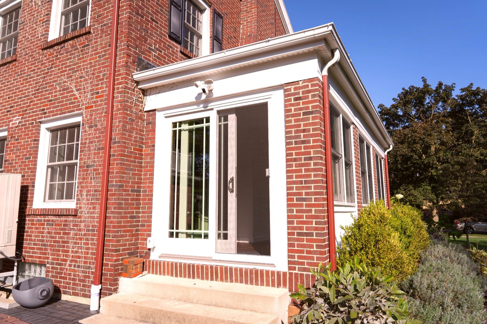 Sunroom addition — finished exterior showing roofline integration with existing home